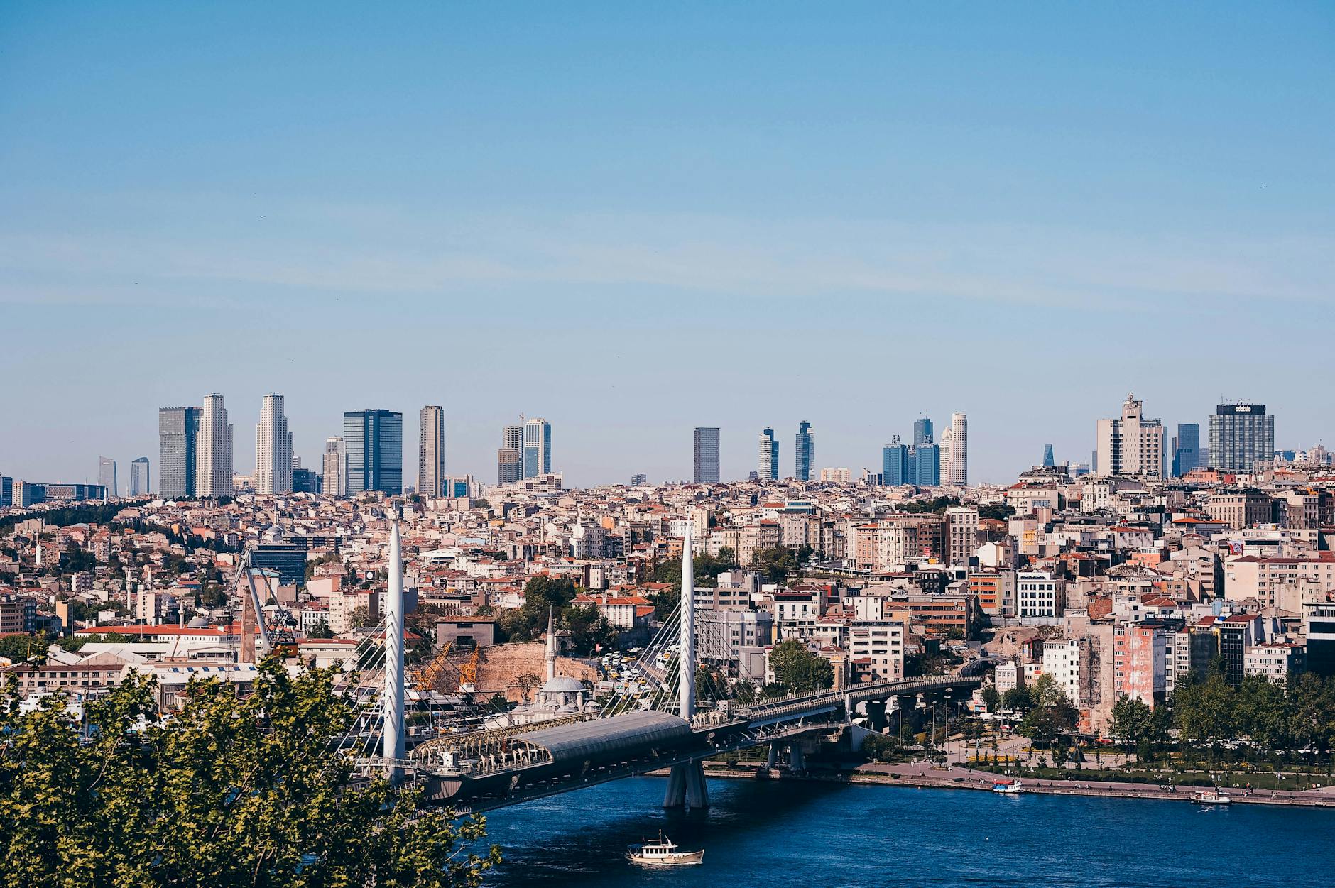 Elevated cityscape view of Istanbul featuring the Golden Horn and distant modern skyscrapers.