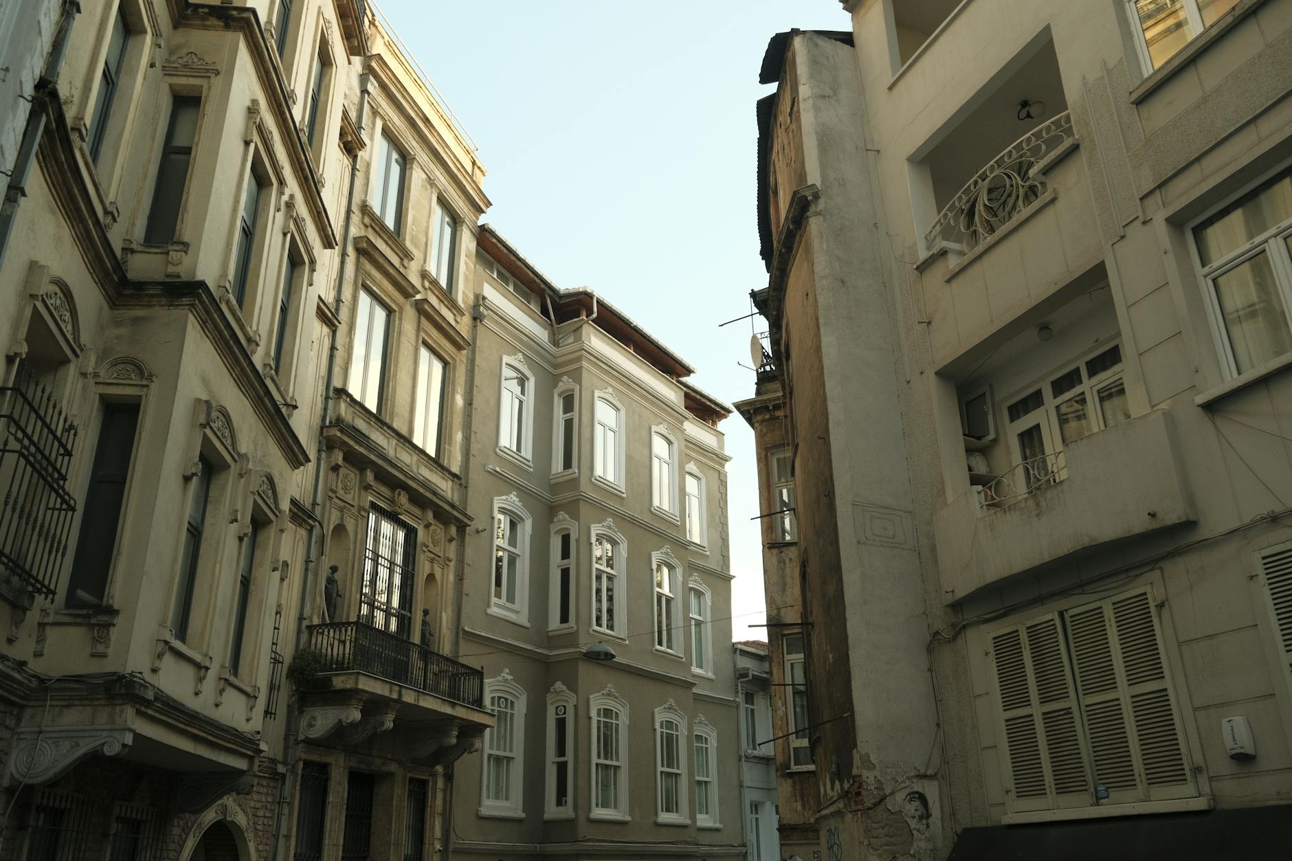 Historic European style apartment buildings line a narrow alleyway in the Çukurcuma neighborhood.