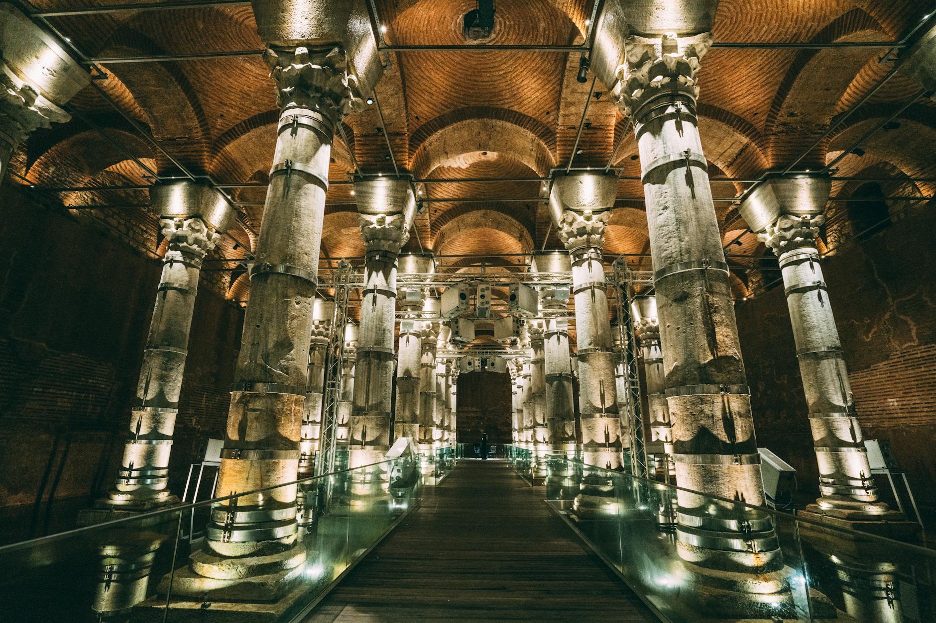 Atmospheric evening lighting illuminates the ancient columns and walkway inside the Basilica Cistern.