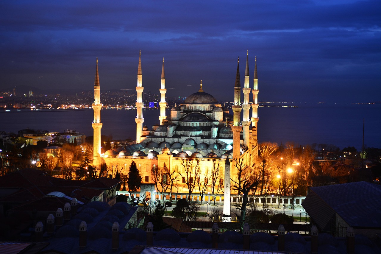 The illuminated Blue Mosque and Egyptian Obelisk are seen from an elevated terrace.