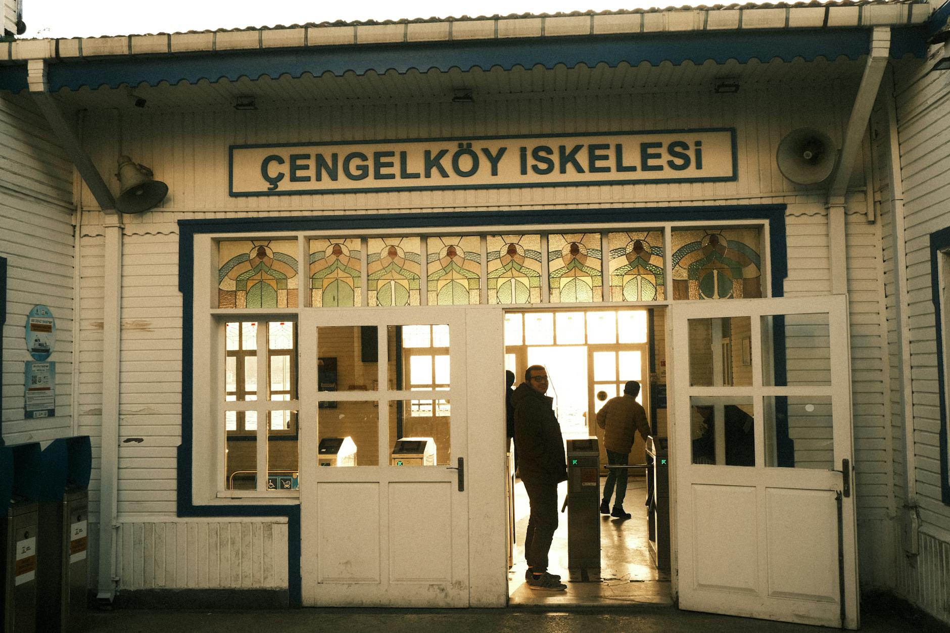 People gather at the historic white entrance of the Cengelkoy ferry terminal in Istanbul.