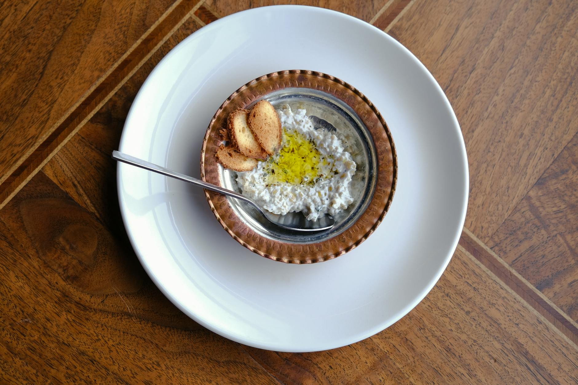 A cold vegetable dip drizzled with olive oil and served with toasted bread.