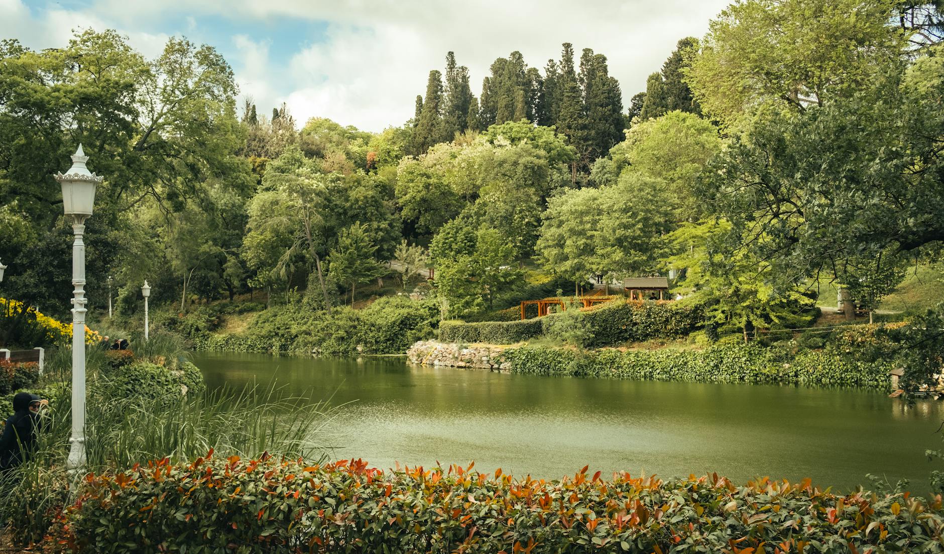The peaceful lake surrounded by dense green trees inside Emirgan Park in Istanbul.