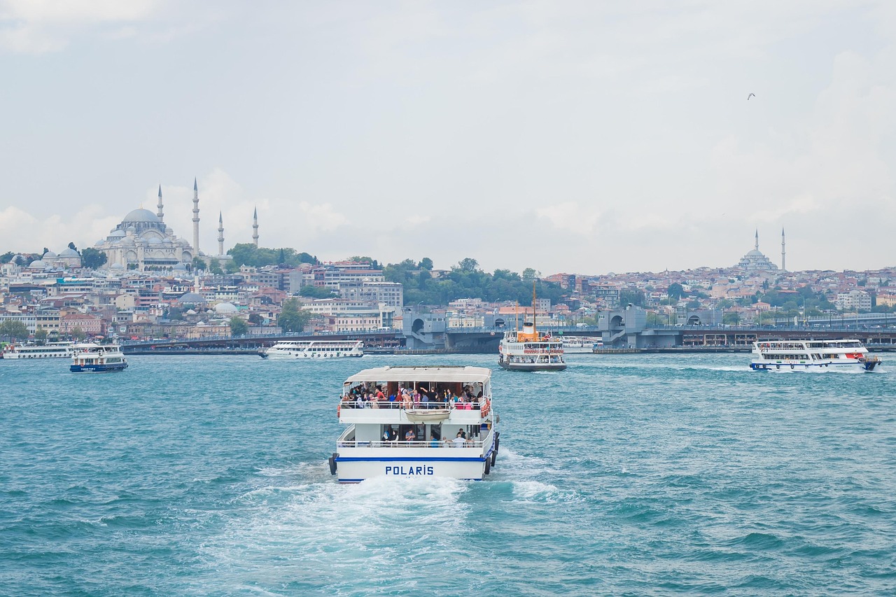 Several public ferries transport passengers across the Bosphorus with the city skyline behind them.