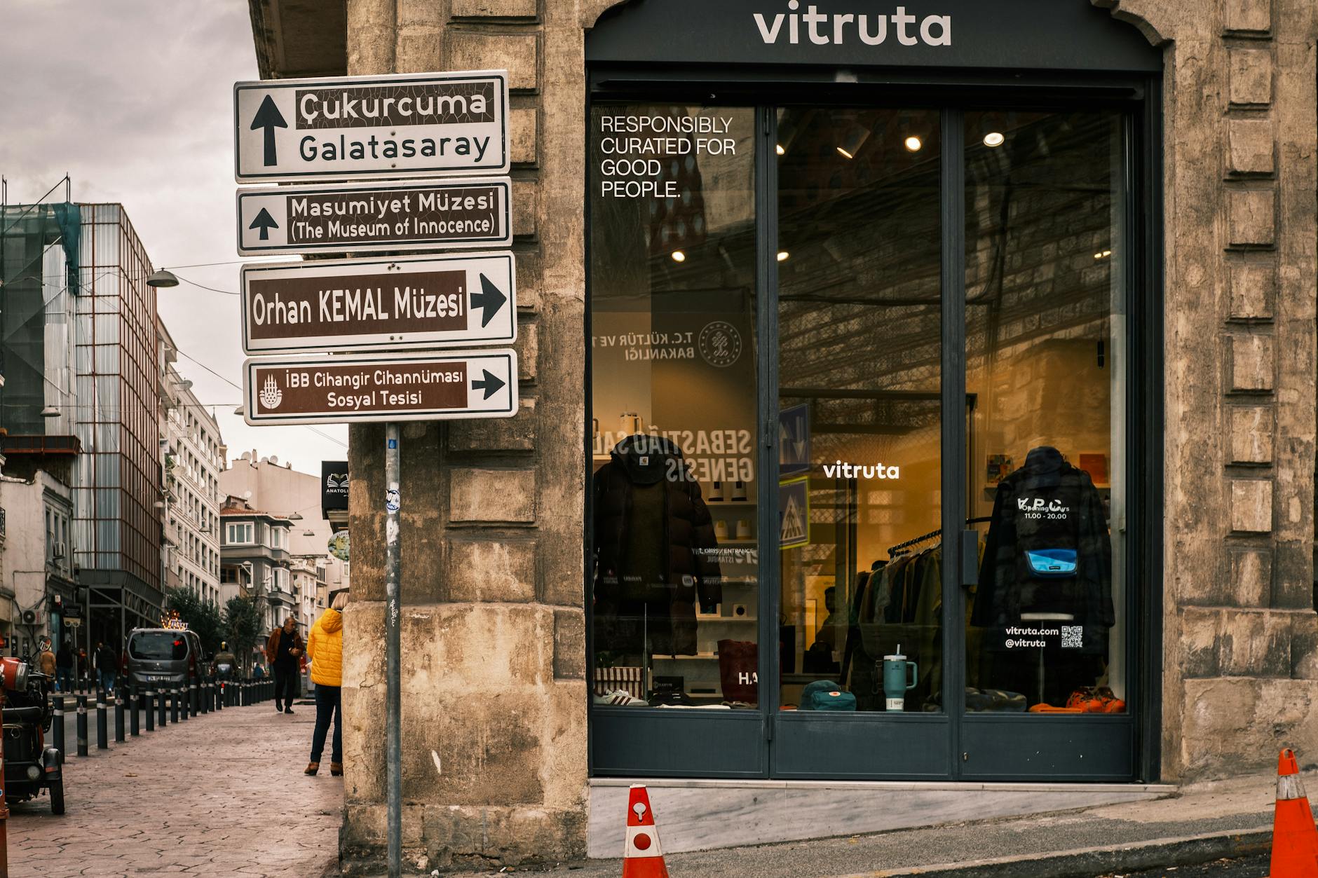 Street signs in Istanbul point towards Çukurcuma and Cihangir near a modern boutique.
