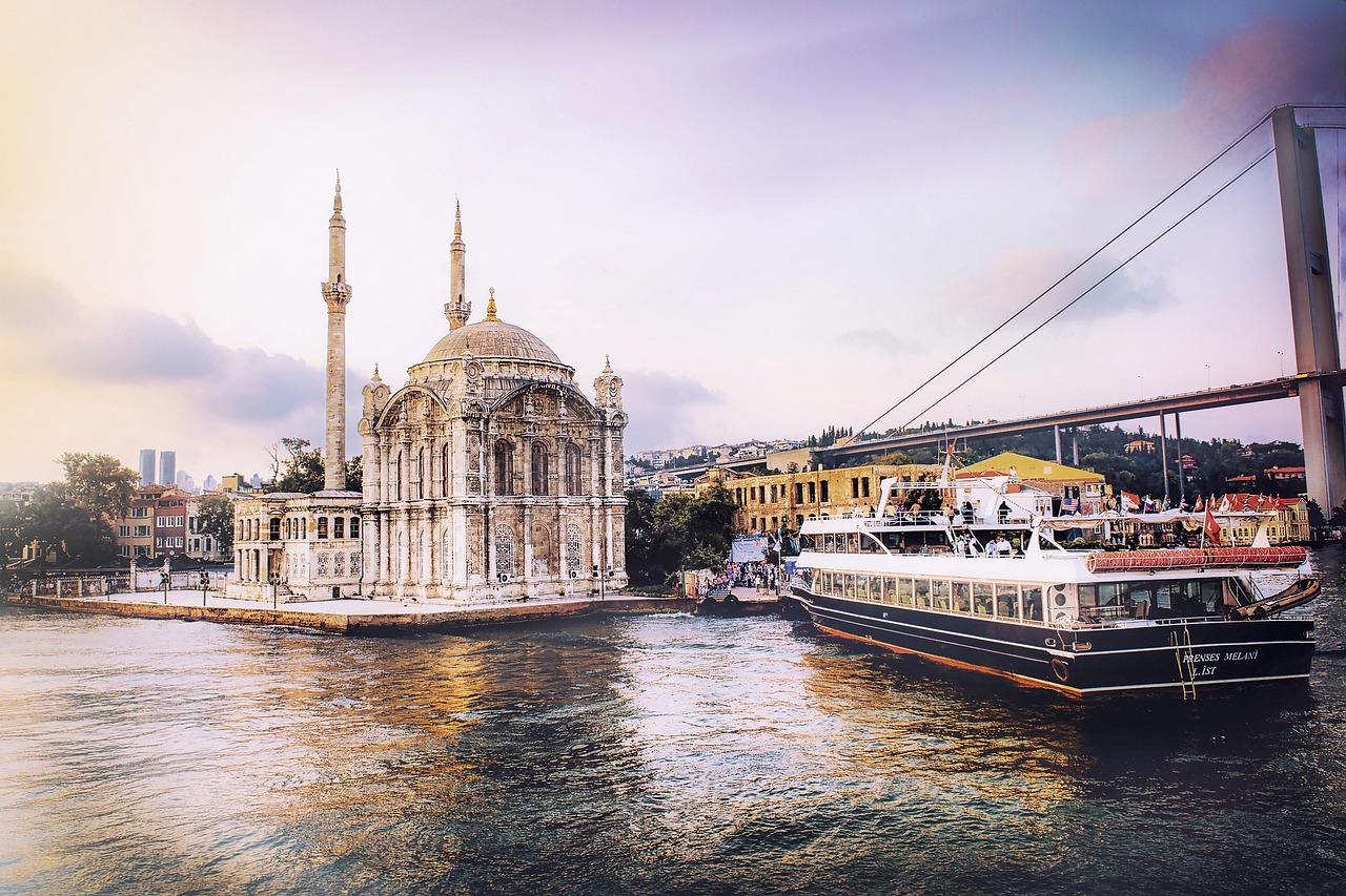 The historic Ortaköy Mosque stands beside the Bosphorus Bridge during a golden sunset.