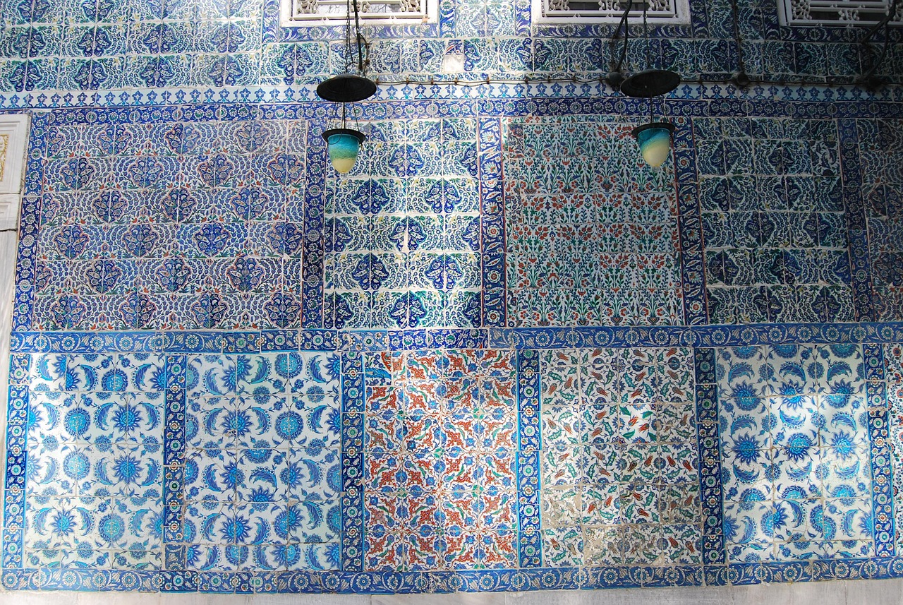 Close-up of richly decorated Iznik tiles showcasing intricate blue, white, green, and hints of red floral and geometric patterns inside the Rustem Pasha Mosque in Istanbul.