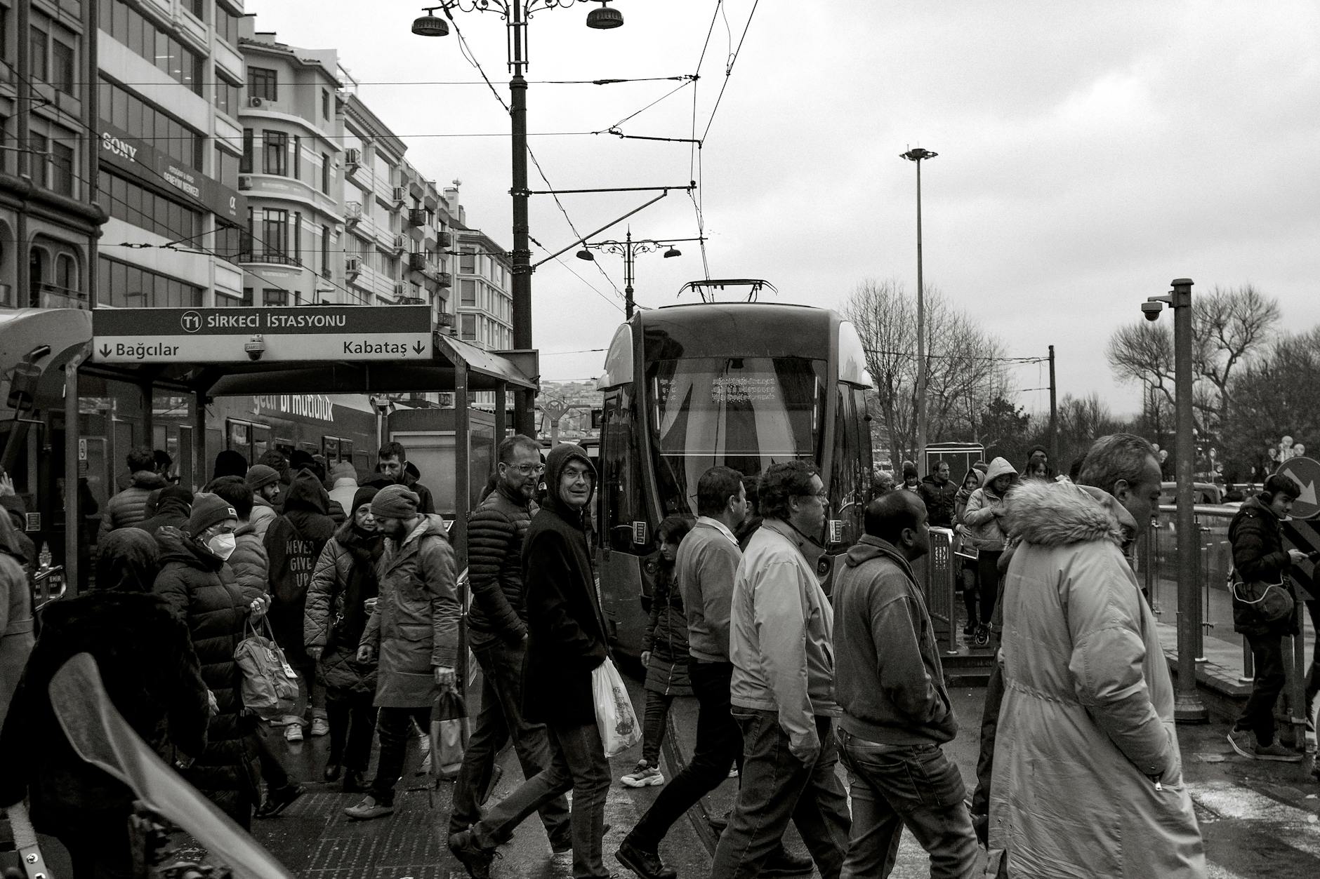 A busy street scene with people walking near the Sirkeci tram station.