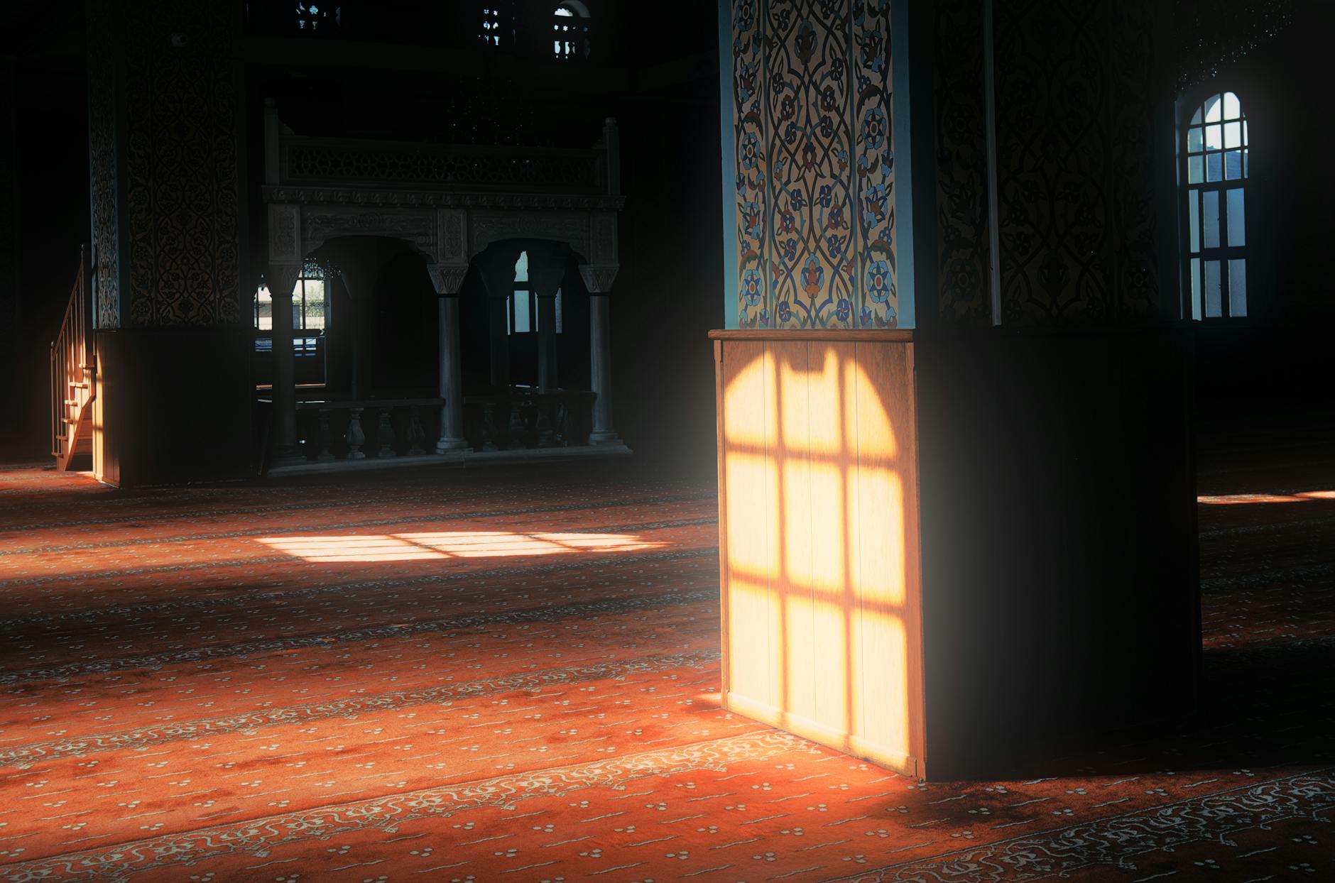 Warm sunlight highlights the floral patterns on a mosque interior pillar.