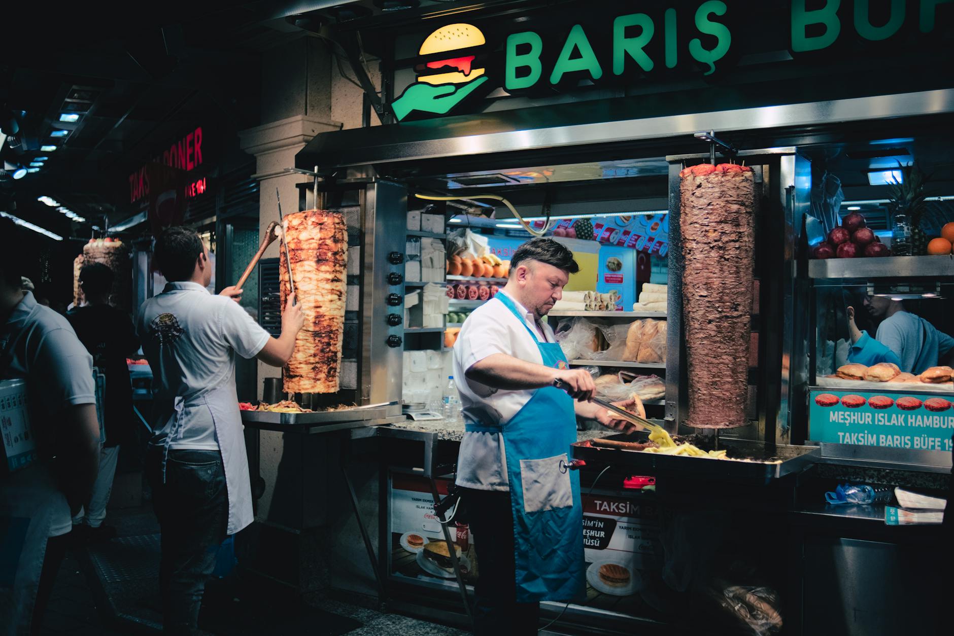 Skilled chefs slice traditional leaf döner from large vertical rotisseries in Taksim.