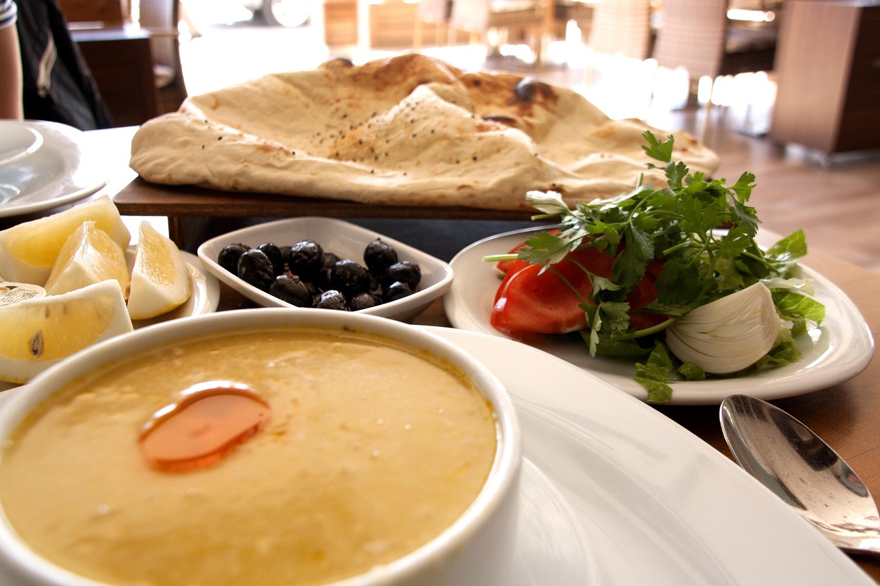 Creamy Turkish lentil soup served with olives, fresh salad, and traditional flatbread.