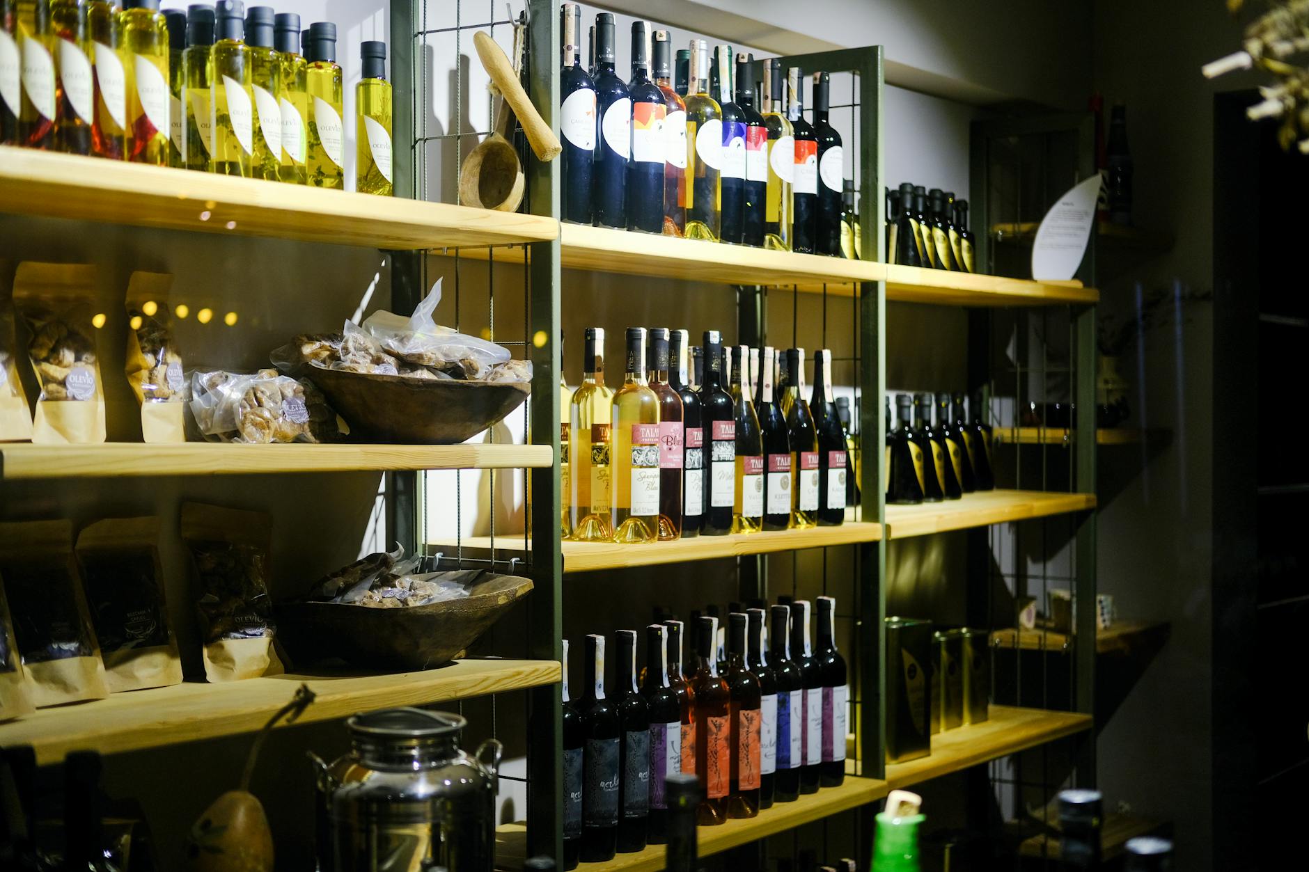 Local Turkish wine bottles and gourmet products arranged on wooden shop shelves.